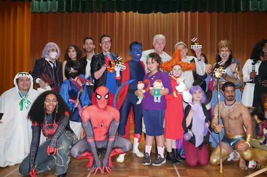 Image is people dressed up as comic or cartoon characters, from Spider-Man to The Rugrats. Posing in front of the camera all smiling.
