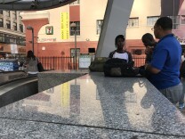 Julian Turner (right), part of Metro's homeless outreach team, chats with two young men outside the Pershing Square stop.