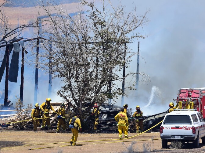 Firefighters help put out a fire near the community of Squirrel Valley in Lake Isabella, California on June 24, 2016.