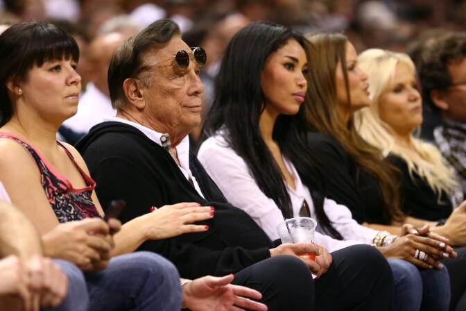 (2nd L) Los Angeles Clippers team owner Donald Sterling with girlfriend V. Stiviano watches the San Antonio Spurs play against the Memphis Grizzlies during Game One of the Western Conference Finals of the 2013 NBA Playoffs at AT&T Center on May 19, 2013 in San Antonio, Texas.