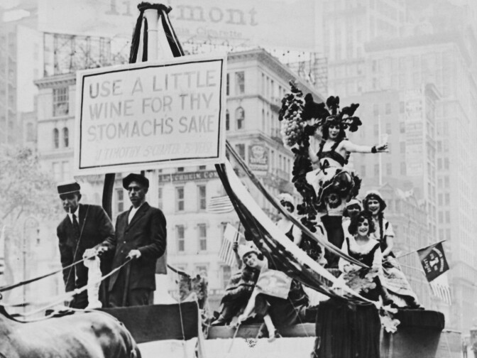 Members of the American Liberties League parading on a horse drawn cart to protest against Prohibition, the banner reads 'Use A Little Wine For Thy Stomachs Sake' and is a quote from the book of Timothy in the Bible, circa 1925. 