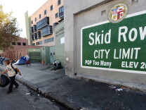 A sign reading 'Skid Row' is painted on a wall next to the Los Angeles Mission, Sept. 22, 2014, in Los Angeles, California. Los Angeles' Skid Row contains one of the largest populations of homeless people in the United States.