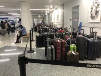Dozens of bags are behind rope lines at the airport