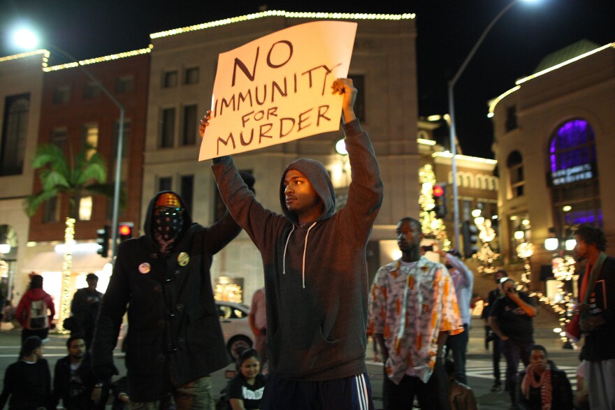 Protesters shut down traffic by blocking the intersection of Wilshire Boulevard and Rodeo Dr. in Beverly Hills after marching from Leimert Park in reaction to the grand jury decision not to indict a white police officer who had shot dead an unarmed black teenager in Ferguson, Missouri on November 24, 2014 in Los Angeles.