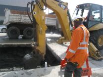 DWP workers move dirt away from 12 inch water main.  