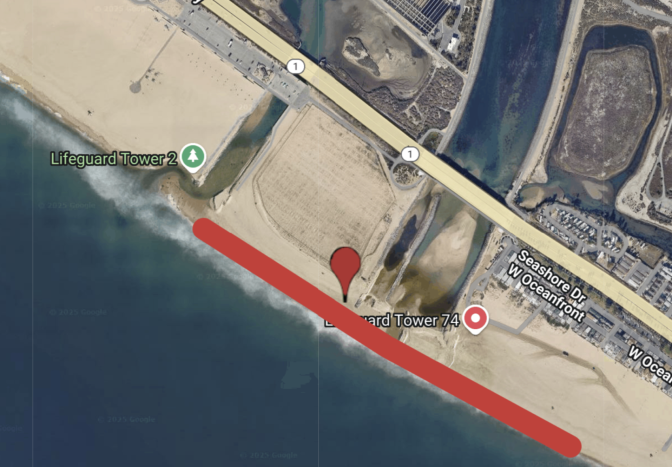 A sign on a beach reads: Keep our beach closed. In the background cranes from a port are visible.