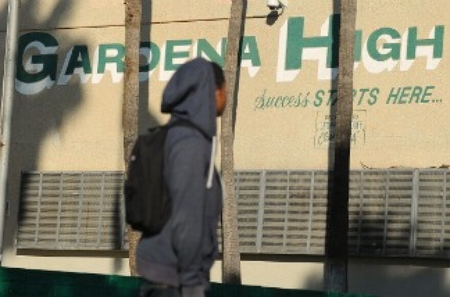 A student walks past the entrance to Gardena High School in Gardena, California January 18, 2011 after two students were shot when a gun went off accidentally in a classroom.