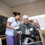 Program assistant Mayra Dittman (L) helps Juanita Gilbert get up to walk at the Lifelong Medical Marin Adult Day Health Care Center on February 10, 2011 in Novato, California.  LifeLong Medical Care in Novato is a state-licensed center that provides adult day health care and activities to nearly 60 Marin County seniors and would be forced to close if California Gov. Jerry Brown's proposed budget cuts were to be approved by the state legislature in order to make up for California's $28 billion deficit. The deep cuts to Medi-Cal would jeopardize up to 300 adult day care centers throughout California and displace nearly 37,000 people that depend on the service. 
