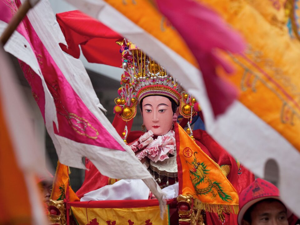 A Mazu statue from a village temple in Meizhou takes part in the birthday parade and will join other statues at the island's main square, where 10,000 believers are gathered.