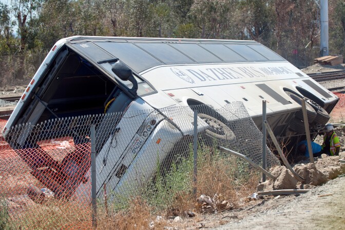 Crews attach cables to the underside to the bus as they pull it upright. More than 50 were injured when a charter bus overturned on the 210 East in Irwindale on Thursday morning, Aug. 22.