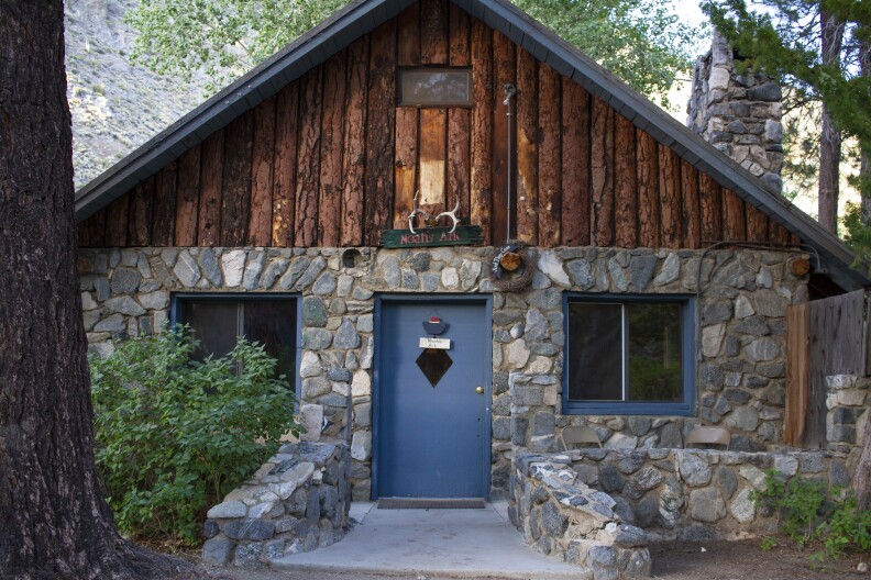 a stone cabin with a wood roof