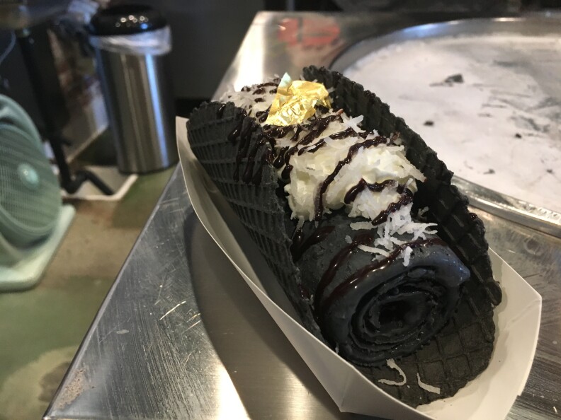 24k ice cream taco includes charcoal ice cream, coconut and gold leaf