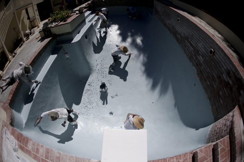 Workers replace the plaster in a swimming pool in Santa Ana, Calif. on Wednesday, Sept. 24, 2014. California swimming pool companies just regaining their financial footing after the recession are now facing a new challenge: a devastating drought that has put the state’s ubiquitous backyard pools under the microscope. (AP Photo/Chris Carlson)