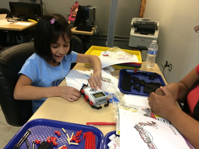 Madelyne Tenorio, 7, works on a project during a robotics and computer class at the Bell Technology Center.