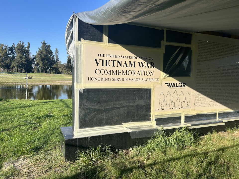 A tarp covers a wall where templates cover black granite