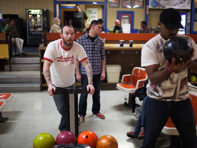 Army veteran Joe McGraw monitors the scoreboard while Marine Corps veteran Luise Gautam (right) prepares to take his turn. Marine Corps veteran Cory Taylor (center) waits his turn. All are Fullerton College students.