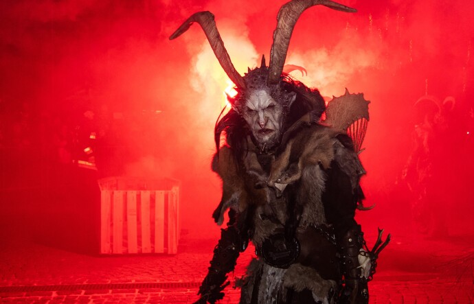 A creature with tall horns and a pale, scrunched face scowls forward.