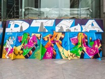 A colorful graffiti art mural on a wall. Large, white letters across the top spell DTLA for Downtown Los Angeles.