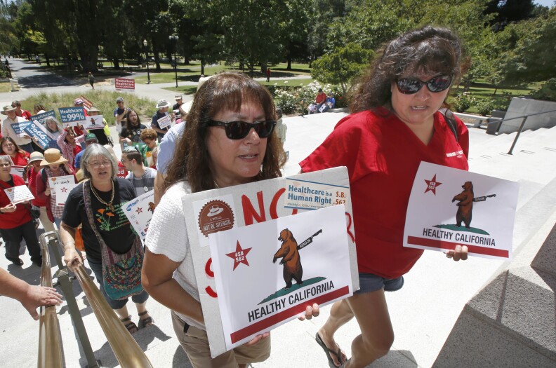 Yolanda Sanchez, left,and her daughter, Michele Sanches-Nelson, a registered nurse, wait in line with other members of the California Nurses Association and supporters to enter the Capitol to call for a single-payer health plan, Wednesday, June 28, 2017, in Sacramento, Calif. The demonstrators were demanding that Assembly Speaker Anthony Rendon, D-Paramount, bring a health care bill, SB562, by state Senators Ricardo Lara, D-Bell Garden, and Toni Atkins, D-San Diego, to a vote in the Assembly. (AP Photo/Rich Pedroncelli)