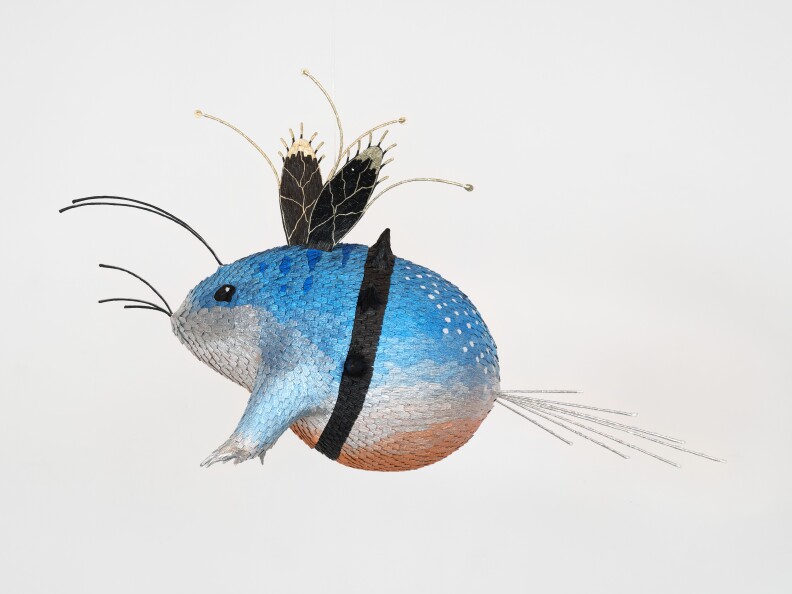 This photo showcases a whimsical sculpture that blends features of a fish and a rodent into a single imaginative creature.