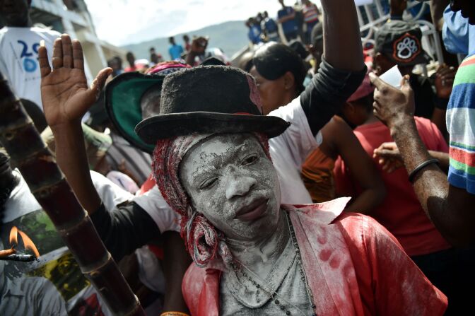 A devotee pretending to be the spirit known as a Gede smiles during a ceremony honoring the Haitian voodoo spirits of Baron Samdi and Gede on the Day of the Dead in the National Cemetery in Port-au-Prince, Haiti on November 1, 2016.