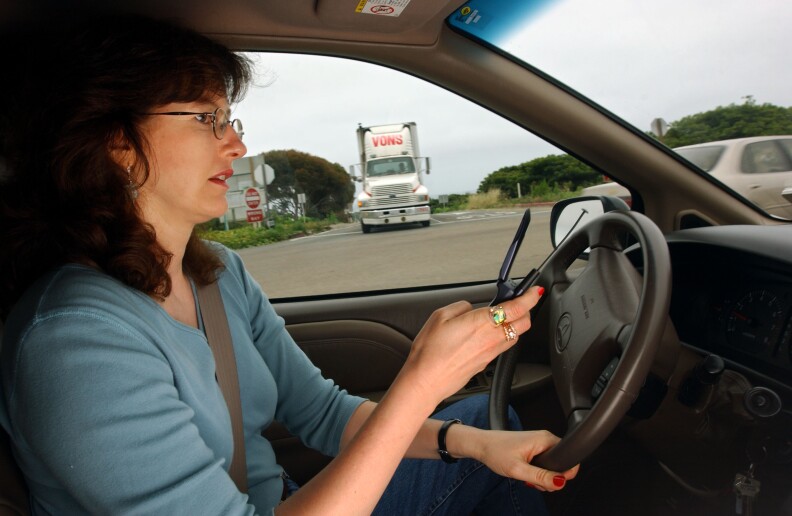 Catherine Singer dials a cell phone in her car as a truck approaches in San Clemente, California. 