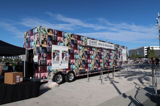 A multicolored van with portraits of Taylor Swift all over it. 