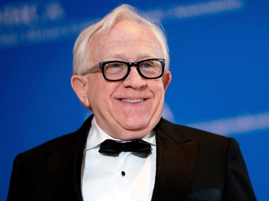 Leslie Jordan wears a tuxedo jacket and bow-tie, he has silver hair and dark-rimmed glasses..