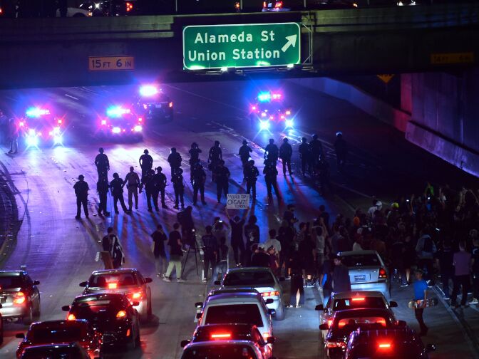 Police and protesters face off on a freeway in downtown Los Angeles, California after midnight early on November 10, 2016 as protesters angry over Donald J. Trump's election as the next US president marched in downtown Los Angeles through the evening and shut down portions of the Hollywood (101) Freeway.
Thousands of protesters rallied across the United States expressing shock and anger over Donald Trump's election, vowing to oppose divisive views they say helped the Republican billionaire win the presidency. / AFP / Frederic J. BROWN        (Photo credit should read FREDERIC J. BROWN/AFP/Getty Images)