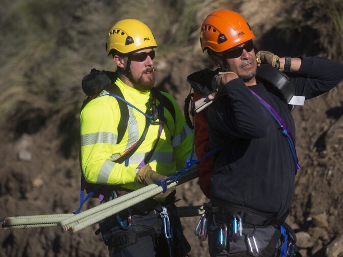 CalTrans trained climbers Chad Dressler, left, and David Rodriguez prepare to bring steel pickets up a mountainside on Tuesday morning, Jan. 6 in Malibu.