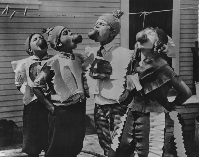 Four children attempting to bite apples on a string at a Halloween party circa 1950's. (Photo by Keystone View/FPG/Getty Images)