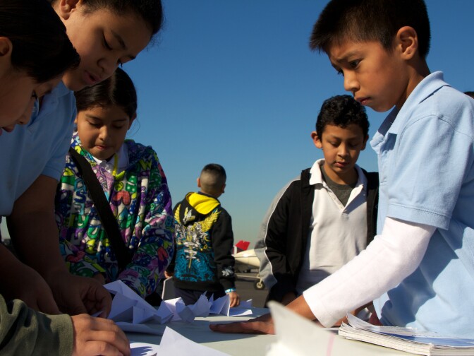 Students feverishly put together their paper airplanes before competing to see who can toss there's the farthest.