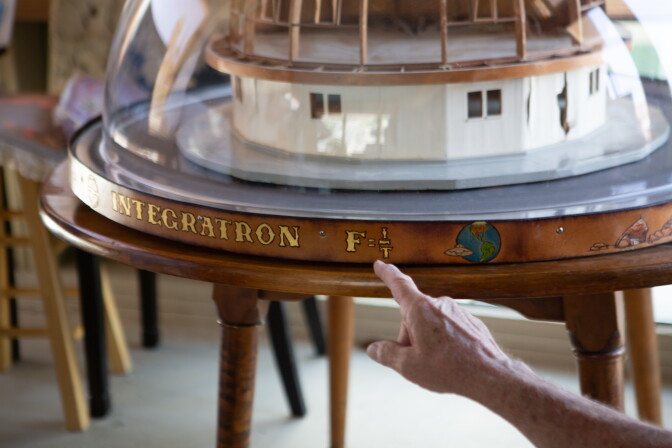 A leather band encircles the base of an architectural model of a domed building. 