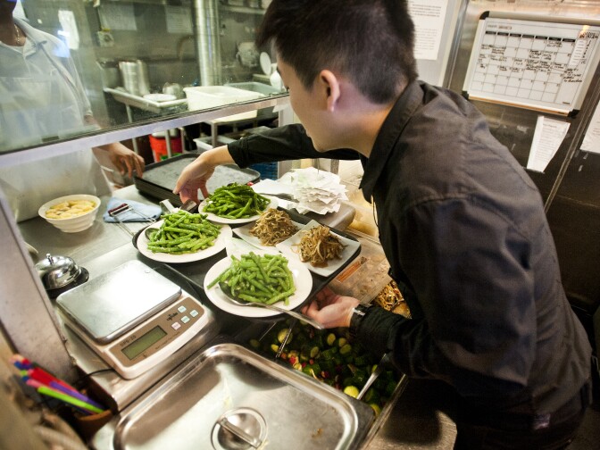 A waiter takes orders from the kitchen. Din Tai Fung has 80 stores worldwide in countries like Japan, Hong Kong, Singapore, and even Austrailia.