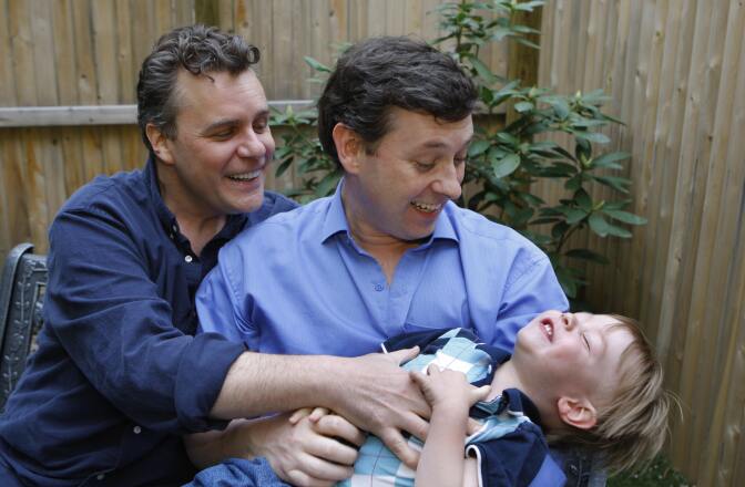 Gay couple Jeffrey Parsons (R) and Chris Hietikko pose with their son Henry Hietikko-Parsons in the garden of their house in New York on May 01, 2008. 