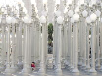 A girl plays under columns of lights in front of the Los Angeles County Museum of Art in Los Angeles, California on February 16,2014. "Urban Light," favorite place for portraits of wedding photographers, is a 2008 large-scale assemblage sculpture by Chris Burden. The installation consists of 202 restored street lamps from the 1920s and 1930s. Most of them once lit the streets of Southern California. The cast iron street lamps are of 17 styles, which vary depending on the municipality that commissioned them. They range from about 20 to 30 feet (6 to 9 meters), are painted a uniform grey and placed, forest-like, in a near grid. The lights are solar powered and switched on at dusk. 
