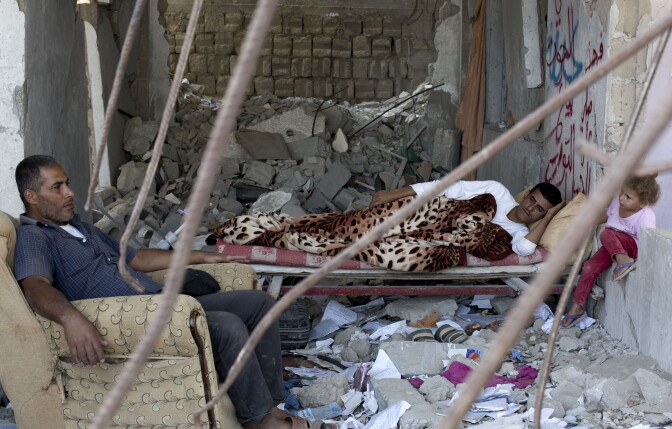 A Palestinian family rests on July 2, 2015, in the rubble of a building that was destroyed during the 50-day war between Israel and Hamas' militants in the summer of 2014, in the al-Shejaeiya neighbourhood, east of Gaza City. AFP PHOTO/MOHAMMED ABED        (Photo credit should read MOHAMMED ABED/AFP/Getty Images)
