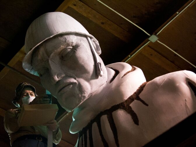 David Lacy of Covina works on a float honoring veterans and children from the Korean War. Lacy glues lettuce seed to soldiers' faces and helmet straps. Lacy himself is a veteran, as he was in the Navy during the Vietnam War.