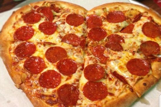 A photo of a heart shaped pepperoni pizza. 