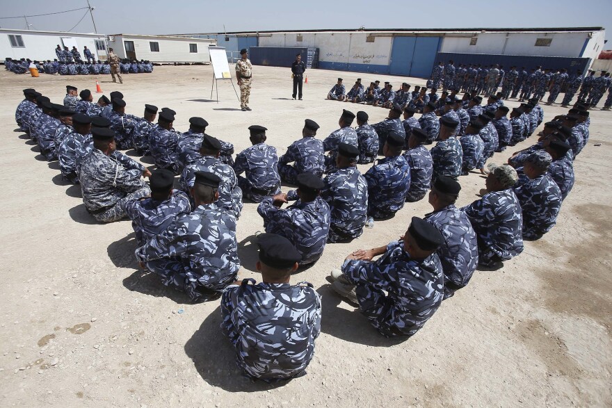 Newly-recruited Iraqi volunteers, wearing police forces uniforms, take part in a briefing at a training centre on June 17, 2014 in the central Shiite Muslim city of Karbala. 
