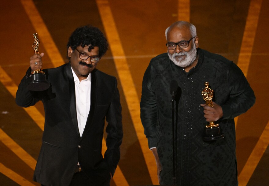 Two men with dark-tone skin gold Oscars