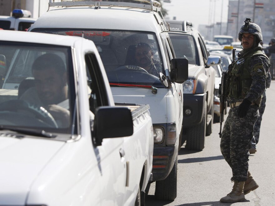 Iraqi security forces monitor traffic Wednesday in the Karradah district of Iraq's capital Baghdad as heavy security measures were imposed following bombings this week.
