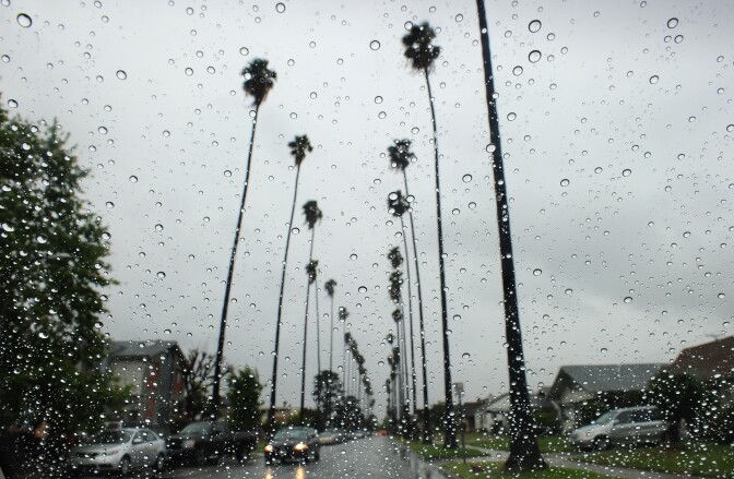 Raindrops are seen on a vehicle's windshield as a car makes its way down a tree-lined street in Alhambra, east of downtown Los Angeles on April 13, 2012 in California.   