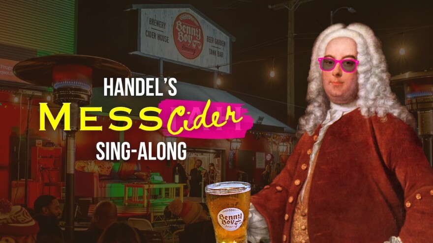 Composer Handel holds a beer and wears pink sunglasses in the foreground. The graphic is laid over a photograph of Benny Boy Brewing during a show.