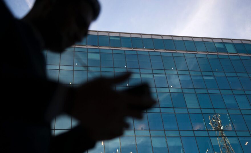A businessman talks on his cell phone as he walks past an office on Oct. 11, 2016 in Washington, DC. (Andrew Caballero-Reynolds/Getty Images)