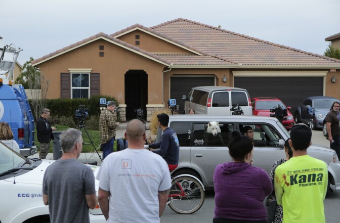 Residents of Perris, California watch as media gather in front of 160 Muir Woods Road, the house where authorities in January 2018 rescued 13 malnourished children held captive by their parents.