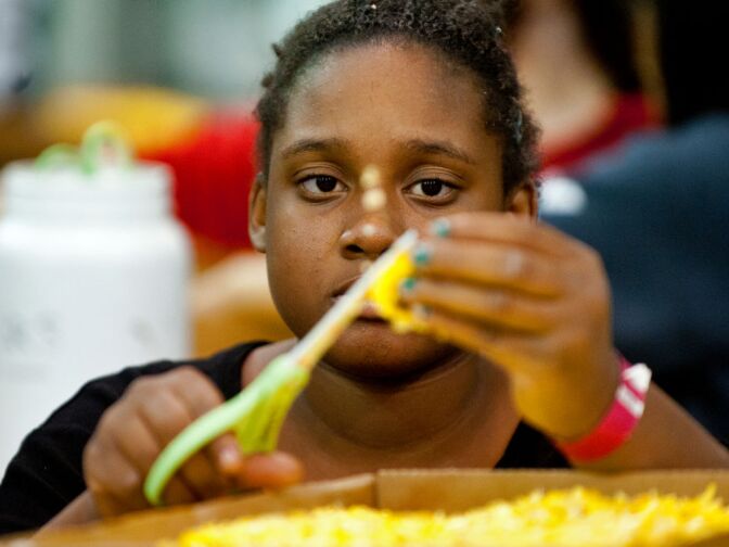 Kekayo Armstrong, 13, cuts up yellow flowers for the City of Hope float. This year's Rose Parade features 41 floats.