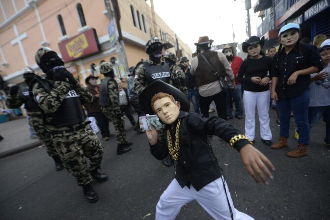 A reveler dressed as a drug trafficker takes part in the traditional "Convite de fieros" festival, as part of All Saints Day celebrations in Villa Nueva, Guatemala on November 1, 2016.
