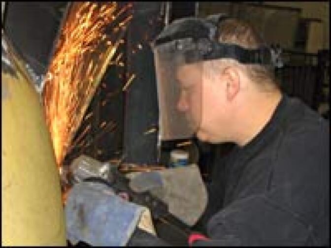 Laid-off worker Rick Siegert plans to turn down a $70,000 buyout to cut his ties to General Motors. He'd rather keep working in the company's Jobs Bank, building art work like this for a community group while still earning a full salary.