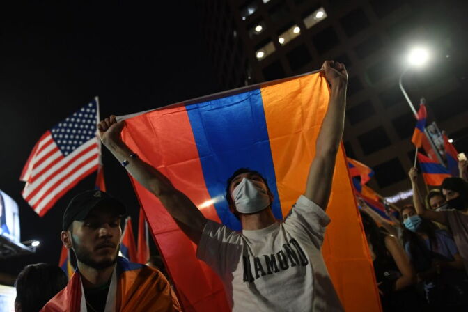 A man holds up an Armenian flag during a protest organized by the Armenian Youth Federation (AYF) outside the Azerbaijani Consulate General in Los Angeles on September 30, 2020 to protest what they call Azerbaijan's "aggression against Armenia and Artsakh" (Nagorno-Karabakh). (Photo by VALERIE MACON / AFP) (Photo by VALERIE MACON/AFP via Getty Images)